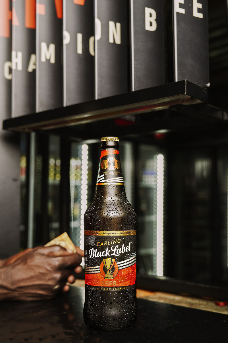 Black Label bottle on a tavern counter, lit by fridge light