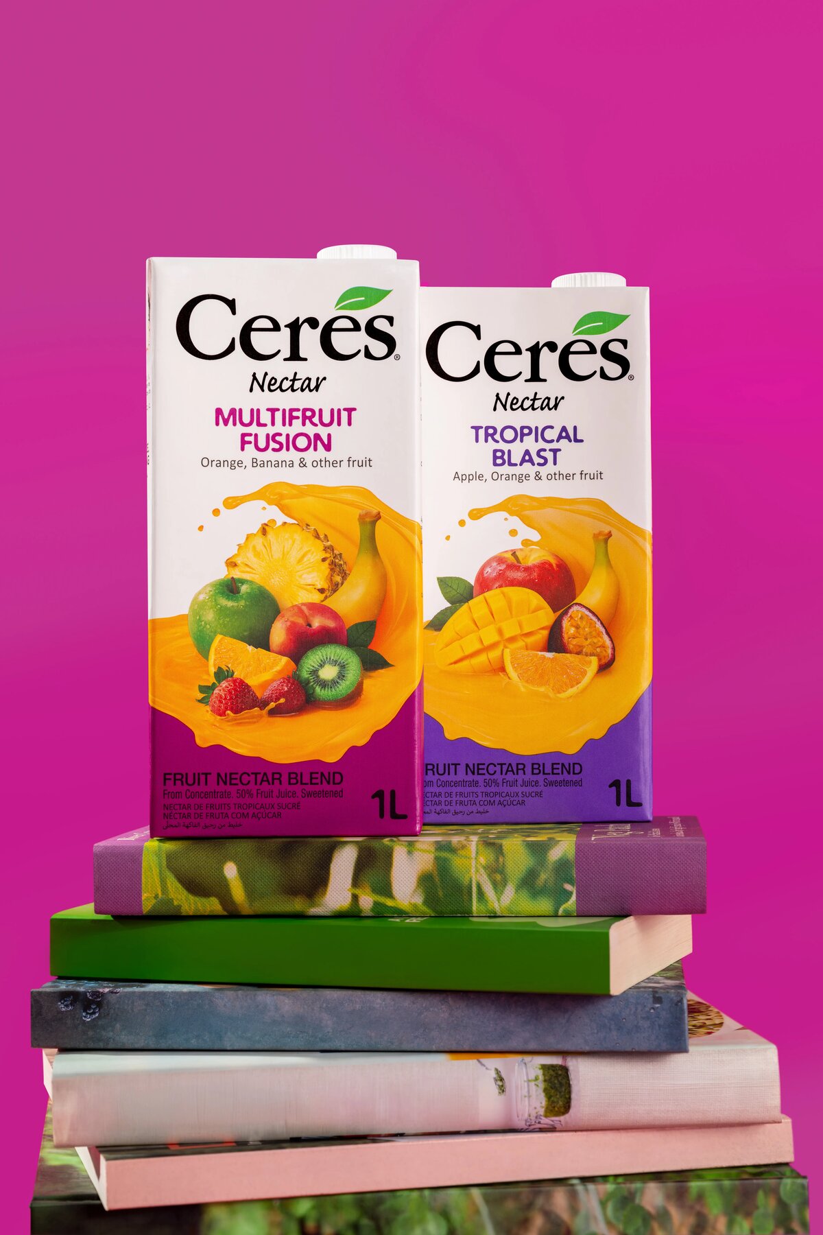 Ceres Nectar Multifruit Fusion and Tropical Blast cartons styled on a stack of books