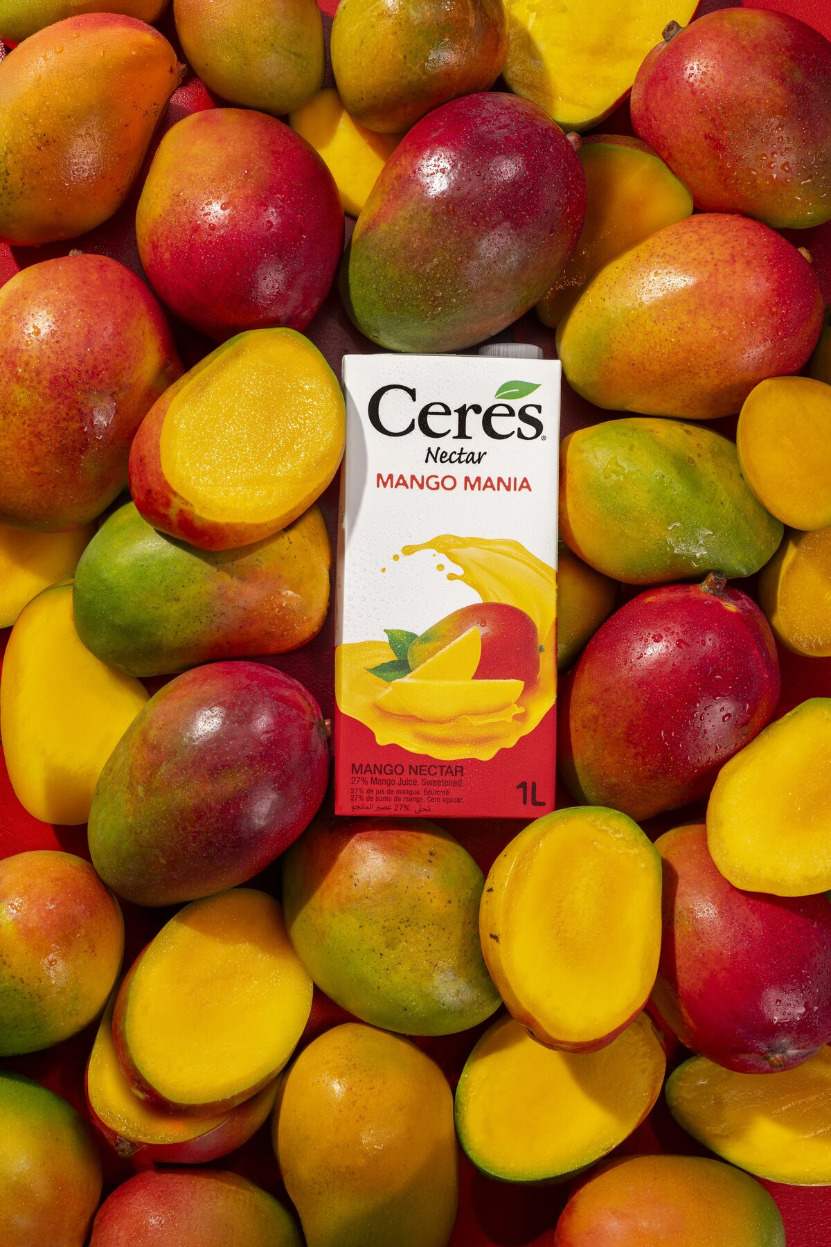 Ceres Nectar Mango Mania carton surrounded by fresh mangoes