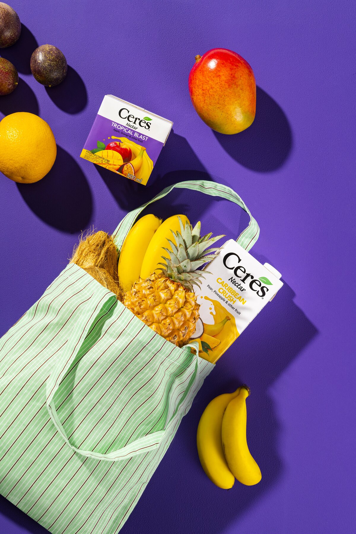 Ceres Nectar Caribbean Crush carton packed into a tote bag with pineapple and bananas