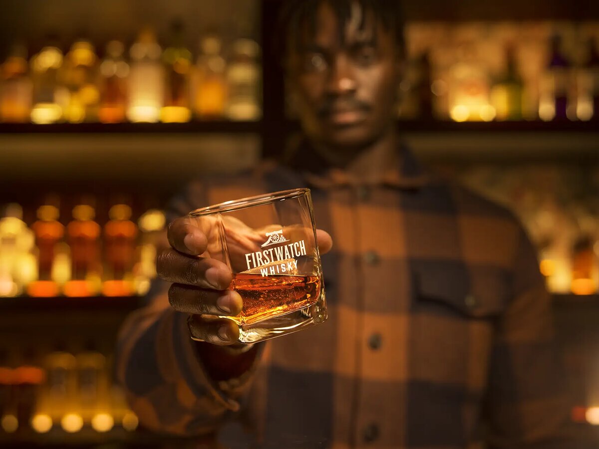 Overhead shot of two Firstwatch Whisky glasses clinking together