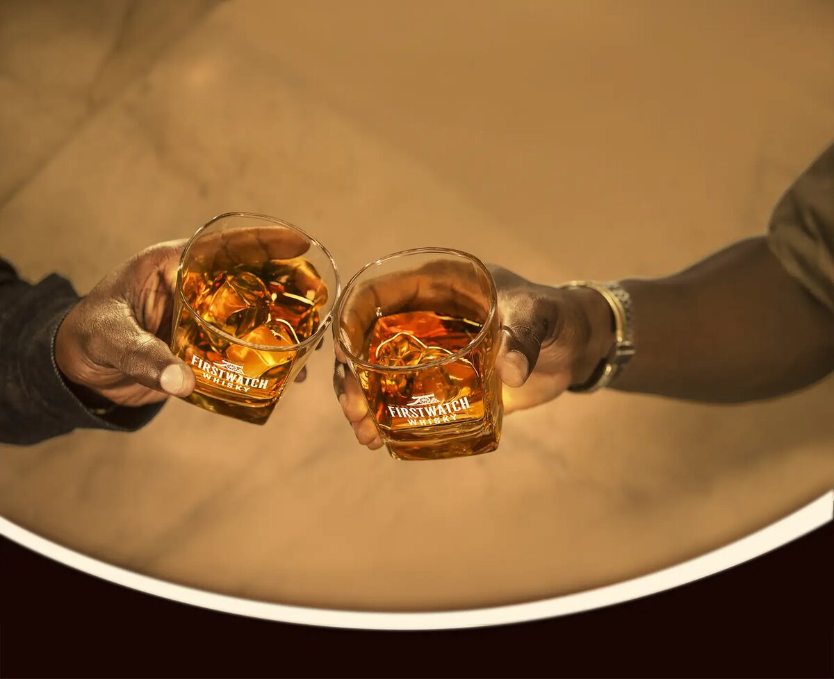 Bartender pouring Firstwatch Whisky into a branded glass
