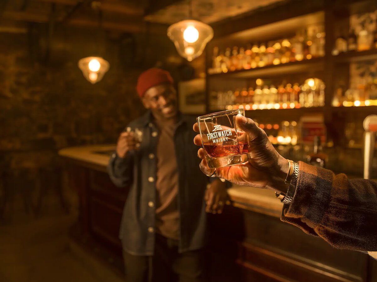 Friends toasting with Firstwatch Whisky glasses at a bar